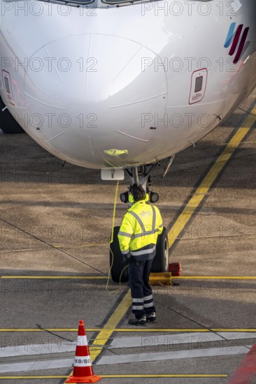 Ground crew talking about intercom with the cockpit, after stopping at the parking position, at the