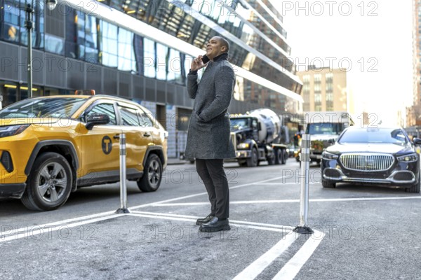 Businessman standing on a bustling manhattan street, having an important conversation on his mobile