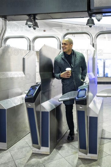 Professional man entering a modern subway station, confidently navigating the turnstile system