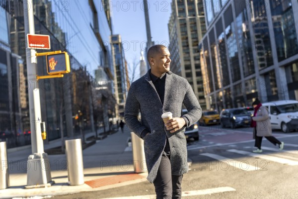 Young man in a stylish coat walks manhattan streets holding a coffee, confidently navigating