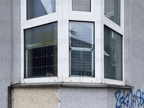Window front, bay window with solar panels used, sustainable and unusual energy generation in