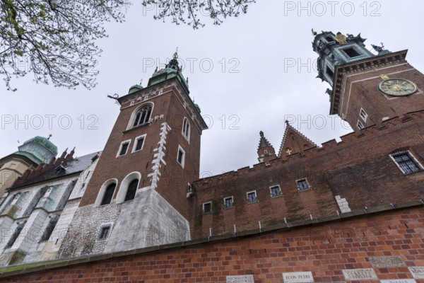North façade of the cathedral on Wavelhügel, tourist group in the rain, Krakow, Poland