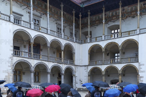 Arcades of the north and east wings of Wavelschloss, in front visitors with umbrellas, Wavelhügel,