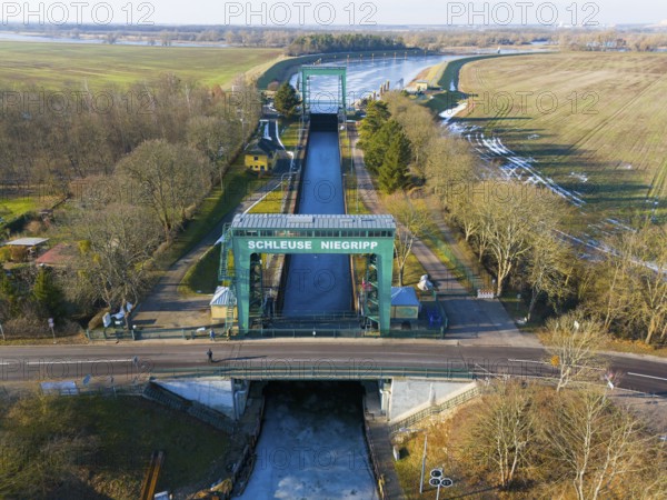 Close-up of Niegripp lock seen over a flat bridge with surrounding forest, aerial view, Niegripp