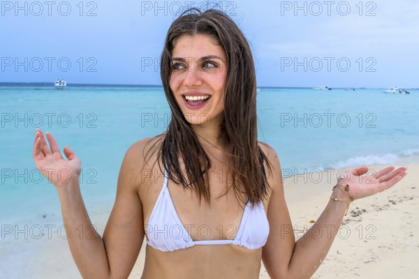 Young woman smiling and gesturing excitedly, experiencing joy and freedom during a relaxing summer