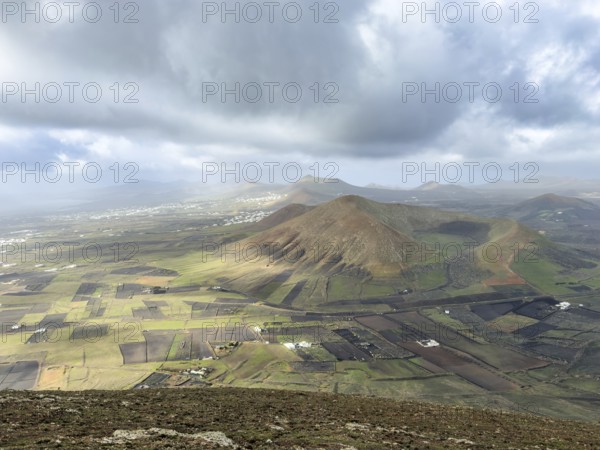 View of Montaña Tesa volcano from Montaña Blanca mountain with cloudy sky, Lanzarote, Canary