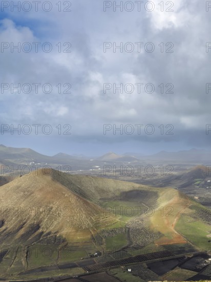 View of Montaña Tesa volcano from Montaña Blanca mountain with cloudy sky, Lanzarote, Canary