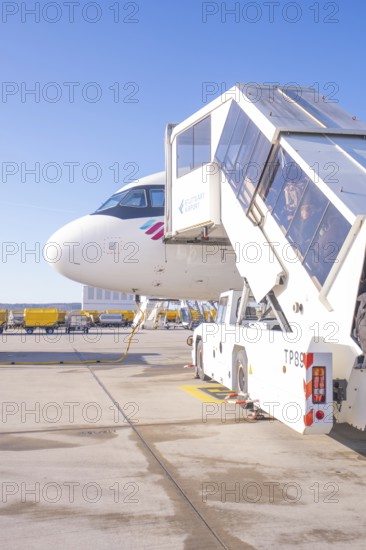 Close-up of an airplane with mobile stairs in the sunshine on the airport apron, Stuttgart Airport,