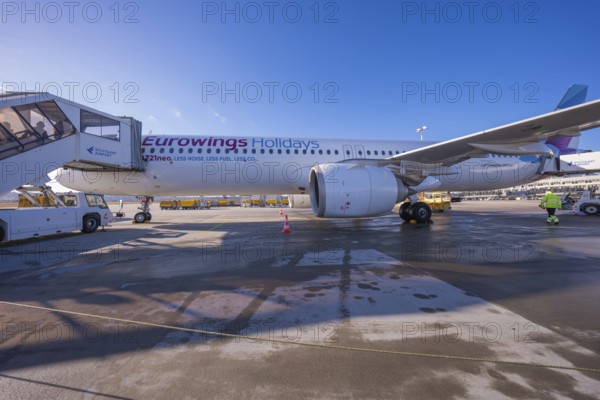 Eurowings aircraft on the ground with mobile stairs and clear blue sky in the background, Stuttgart