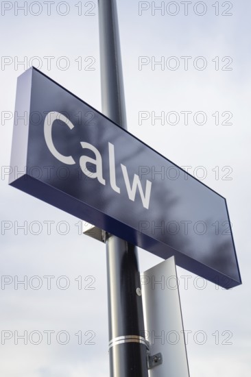 A simple town sign with the name Calw in the open air next to a street lamp, taking off the Hermann
