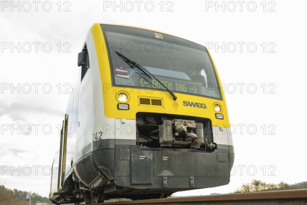 Yellow and grey SWEG vehicle on the rails against cloudy sky, taking off the Hermann Hessebahn,