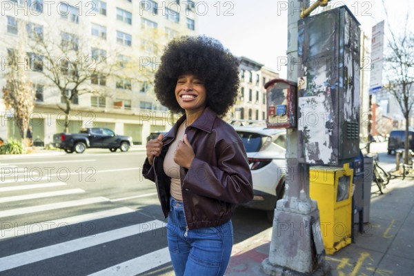 Young african american woman with a big afro hairstyle and smiling face standing on a new york city