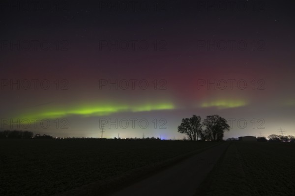 Northern lights (aurora borealis) glow red and green in the evening sky over Germany, Frankfurt am