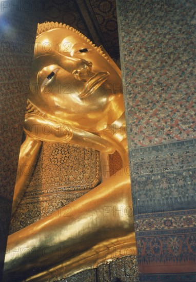 Reclining Buddha in Wat Po. The reclining Buddha symbolizes the last earthly hours in front of