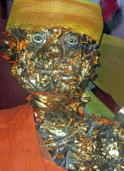 Statue of a monk in a Buddhist temple decorated with gold plates. Buddha, Buddhism, religion,