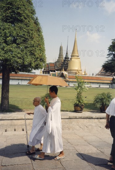 Bhikkhuni, Buddhist nuns walking with parasol in front of Wat Phra Kaeo, (Temple of the Emerald
