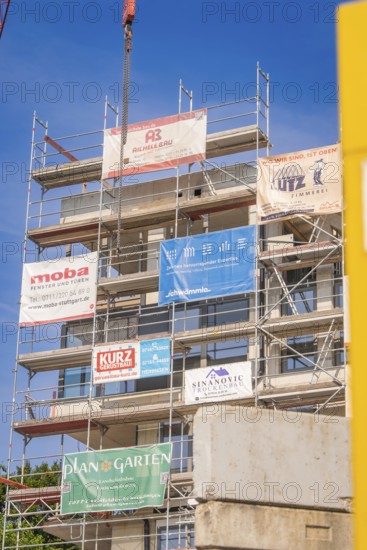 Multi-storey scaffolding on a building with various company banners, carpentry, new building,