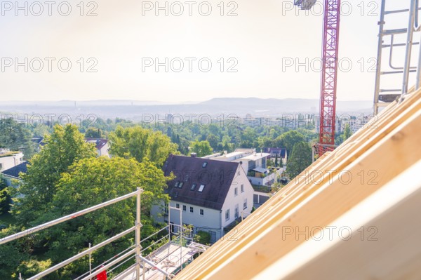 A view from a roof shows a landscape with trees and a crane in the background, carpentry, new