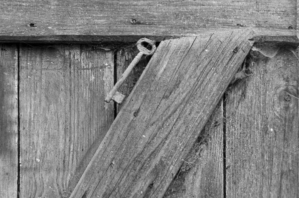 Key on a stable door on a former Franconian farm, black and white, Bavaria, Germany