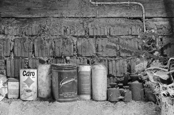 Old weights and cans for storing screws etc. in a hayloft, on a former Franconian farm, black and