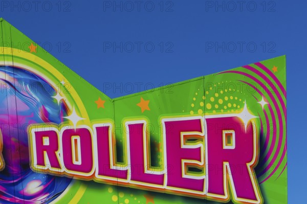 Close-up of the word Roller painted in purple fluorescent paint on banner at Fun Show traveling