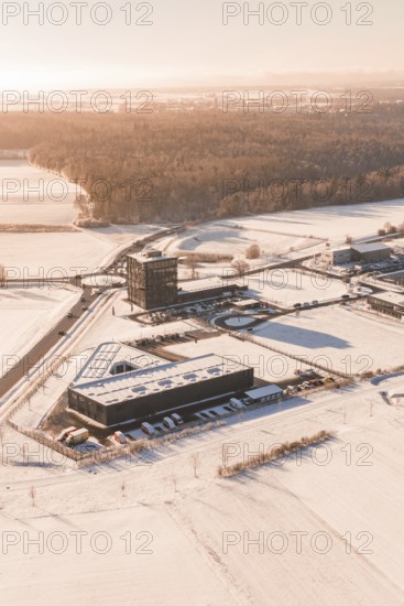 Snow-covered industrial area surrounded by extensive fields in wintry weather, Nagold, Calw