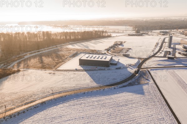 Snow-covered industrial plants and fields under clear sky at sunrise, Nagold, Calw district, Black