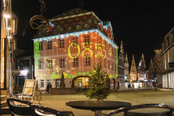 Historic building at night with colorful light projection in the festively decorated city center,