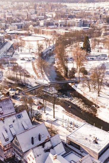 Wintery cityscape with river and bridge, houses and roads covered by snow, Nagold, Calw district,