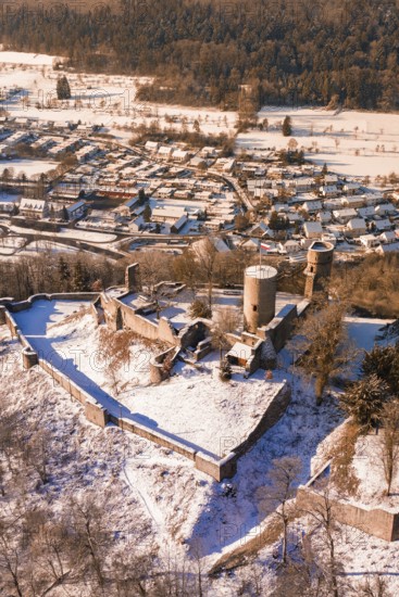 A snowy castle with medieval towers looking over a village of small houses, Nagold, Calw district,