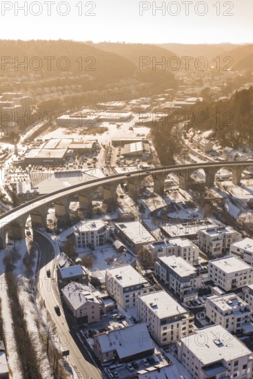 Viaduct over snow-covered residential areas in a city, with hills in the background, Nagold, Calw