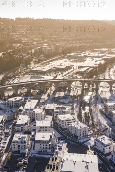 Aerial view of a viaduct over a snowy town surrounded by hills in morning light, Nagold, Calw