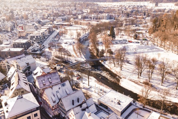 Snowy town with a river and a bridge, surrounded by trees and houses, Nagold, Calw district, Black