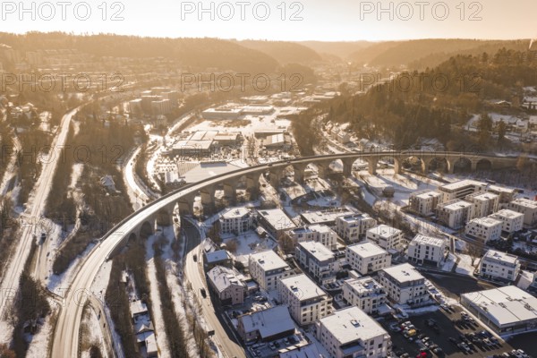Aerial view of a viaduct and snowy cityscape surrounded by hills and roads, Nagold, Calw district,