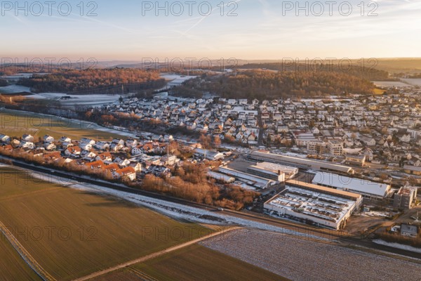 Aerial view of a settlement in winter surrounded by fields and roads, under blue sky, Althengstett,