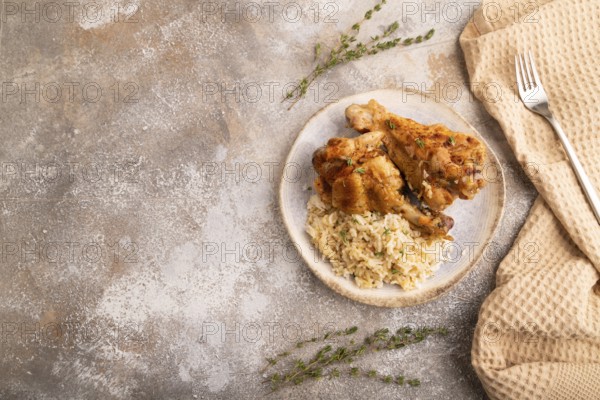 Fried Turkey Wing with spices and rice on brown concrete background and linen textile. top view,