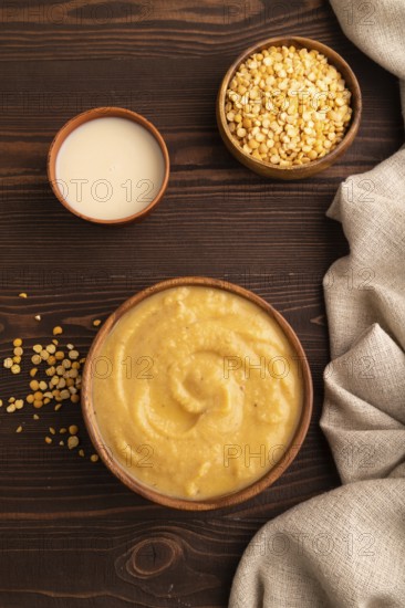 Pea cream soup, Puree, porridge in wooden bowl on wooden background and linen textile. Diet,