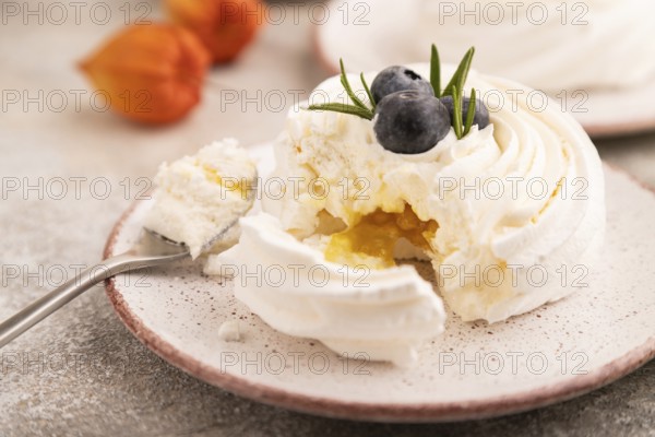 Pavlova Meringue dessert with crisp meringue and blueberry, cup of coffee, on brown concrete