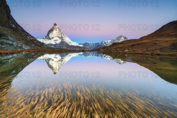 Matterhorn at 4, 478?m, iconic symbol of Switzerland, reflected in Riffelsee Lake at sunrise in