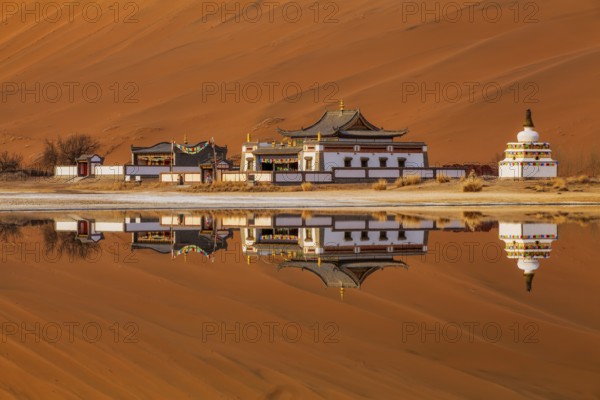 Reflection of Badain Jaran Temple by the shore of a lake, Tibetan-Buddhist temple, Badain Jaran