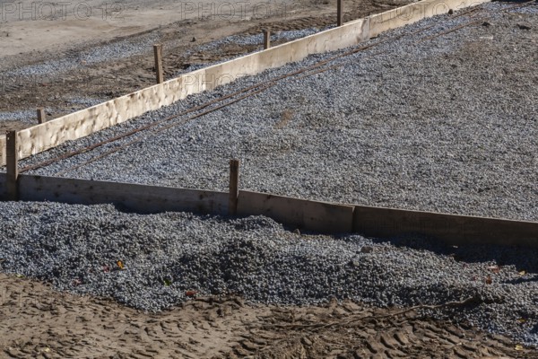 Wooden concrete pouring forms and bed of crushed and compacted stone aggregate to rest concrete