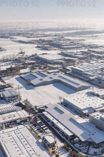 Snow-covered industrial area with a variety of buildings under clear skies, Wolfsberg industrial