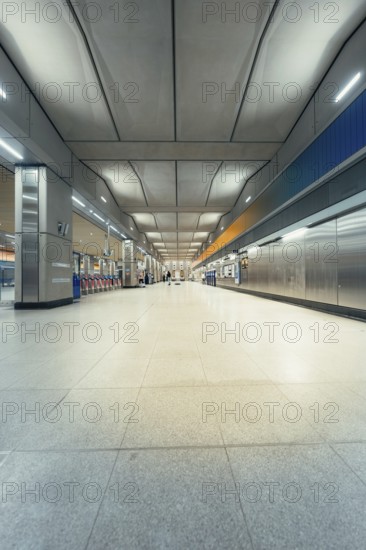 Large, empty station corridor with distinctive ceiling construction and brightness, London, United