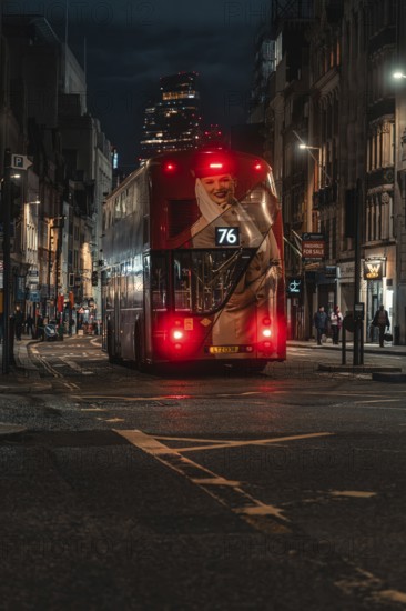 Double-decker bus travels at night through an illuminated city street surrounded by buildings,