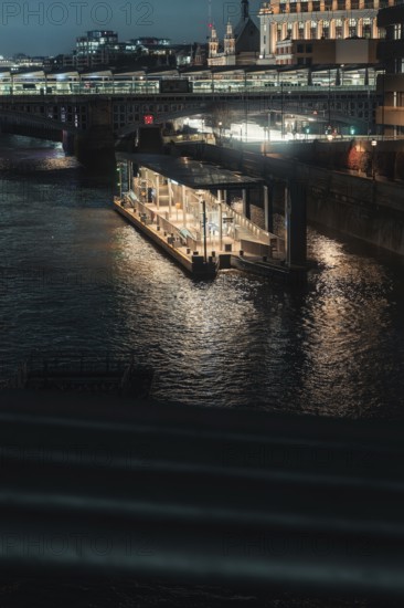 Nocturnal river landscape with illuminated bridges and buildings in the city, London, England,