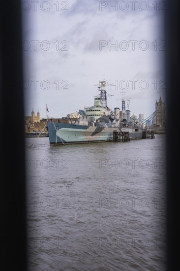 View between two structures of a ship in the river in front of historic towers, HMS Belfast,