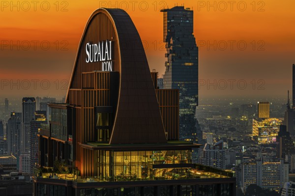 Over the rooftops of Bangkok, sunset, roof structure of the luxury residential residence Supalai