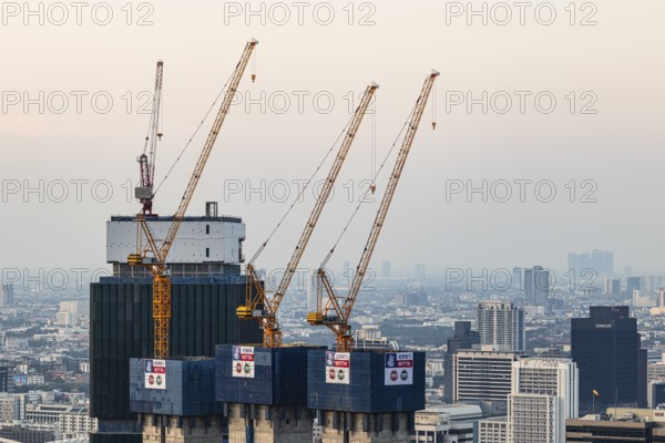 Over the rooftops of Bangkok, construction of a new high-rise building with construction cranes,