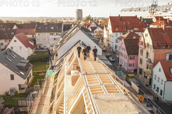 Workers on a new roof with a view of a colorful urban environment, carpentry, renovation, roof