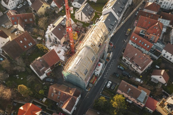 Bird's-eye view of residential area with focus on a construction site and surrounding houses,
